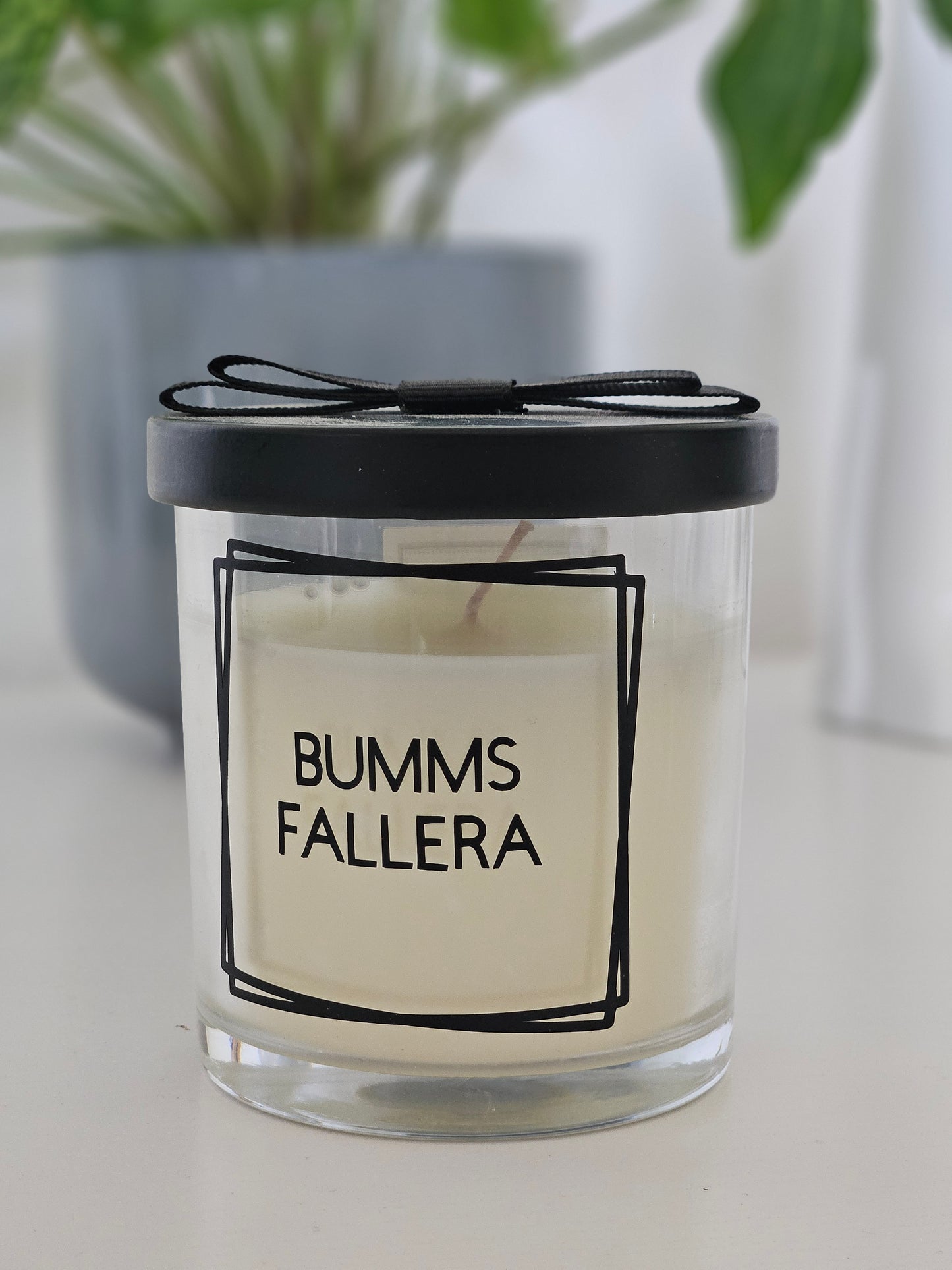 Eine Duftkerze mit Deckel und einem frechen Spruch auf dem Glas. Von rechts fotografiert mit Deckel zu.