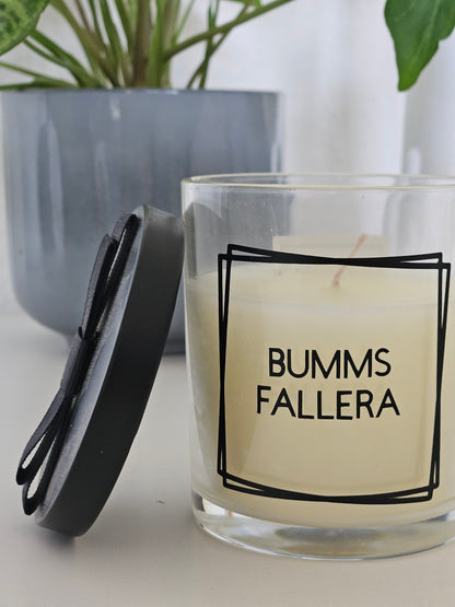 Eine Duftkerze mit Deckel und einem frechen Spruch auf dem Glas. Von links fotografiert.