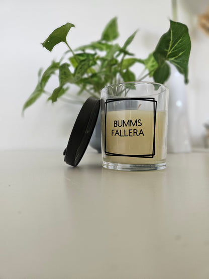 Eine Duftkerze mit Deckel und einem frechen Spruch auf dem Glas. Von unten fotografiert.
